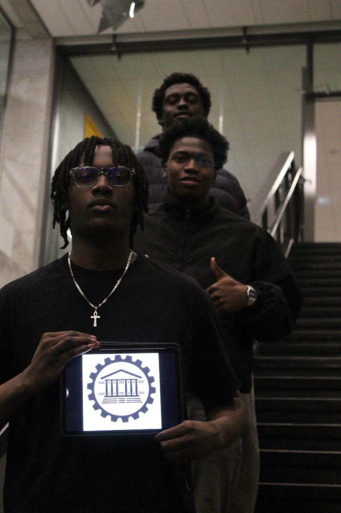 Three students on a staircase, one holding a tablet with a uOttawa logo